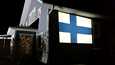 Tero Kankaanpää projisoi Suomen lipun kotinsa seinälle juhlapäivän kunniaksi.