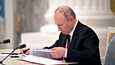 Presidentti Vladimir Putin allekirjoittaa sopimukset, joissa hän tunnustaa Itä-Ukrainan separatistialueet.