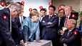 Kuvassa oikealta vasemmalle: 1. Yhdysvaltain presidentti Donald Trump, 2. Valkoisen talon turvallisuusneuvonantaja John Bolton, 3. Japanin varaulkoministeri Kazuyuki Yamazaki, 4. Japanin pääministeri Shinzo Abe, 5. Japanin edustajainhuoneen jäsen Yasutoshi Nishimura, 6. Saksan liittokansleri Angela Merkel, 7. Ranskan presidentti Emmanuel Macron, 8. Britannian pääministeri Theresa May, 9. Trumpin talousneuvonantaja Larry Kudlow.