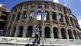 Yksinäinen pyöräilijä Colosseumin edustalla Roomassa sunnuntaina.