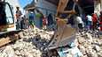 Pelastustyöntekijät kaivavat rakennusten raunioita Haitin Les Aglaisissa.