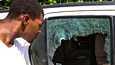 Ohikulkija tarkasteli presidentti Jovenel Moïsen asunnon ulkopuolelle pysäköidyn auton vaurioita keskiviikkona Port-au-Princessä. 
