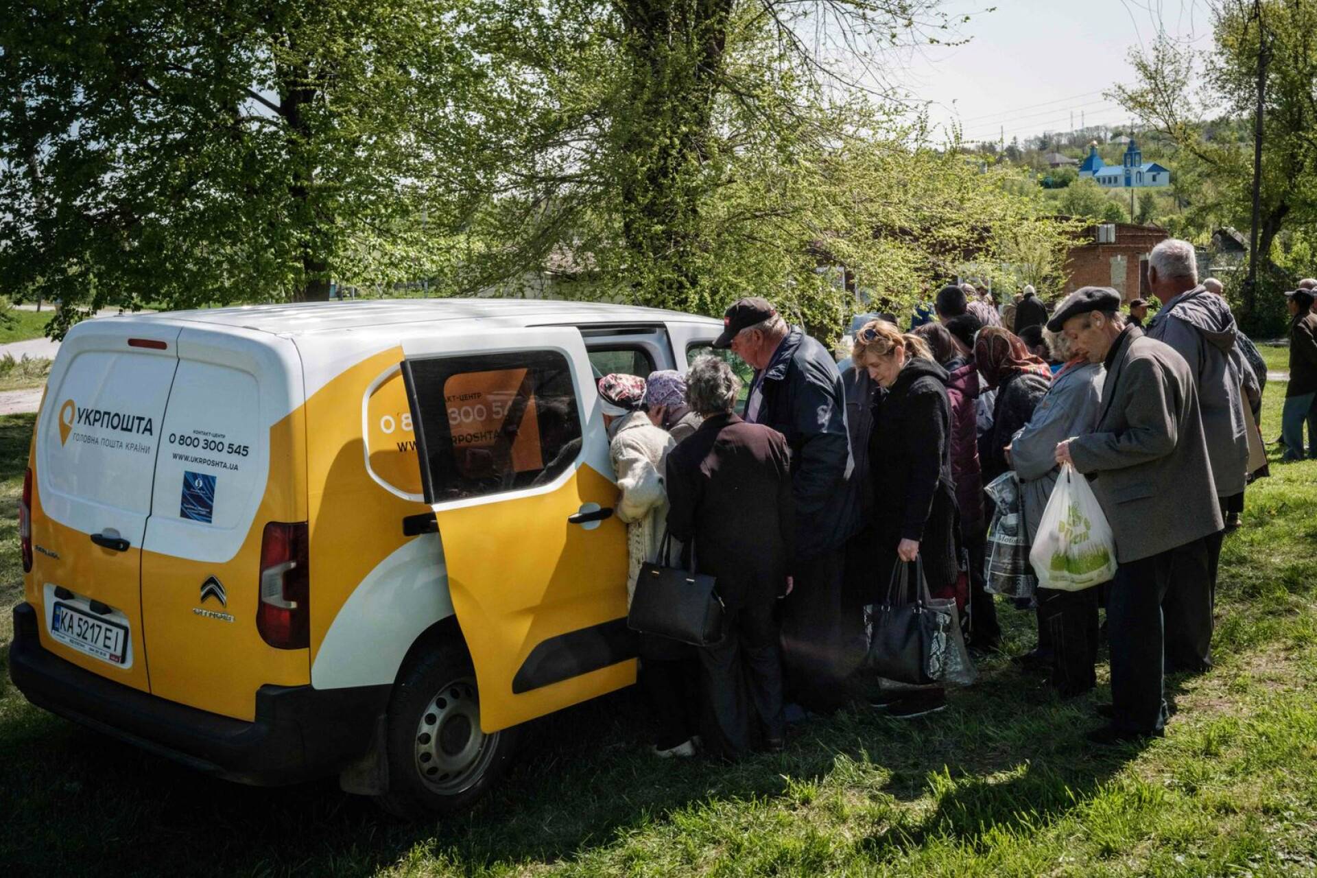 Ihmiset saapuivat hakemaan eläkkeitään postiautolta taistelujen jatkuessa Mayakyssa itäisessä Ukrainasta.