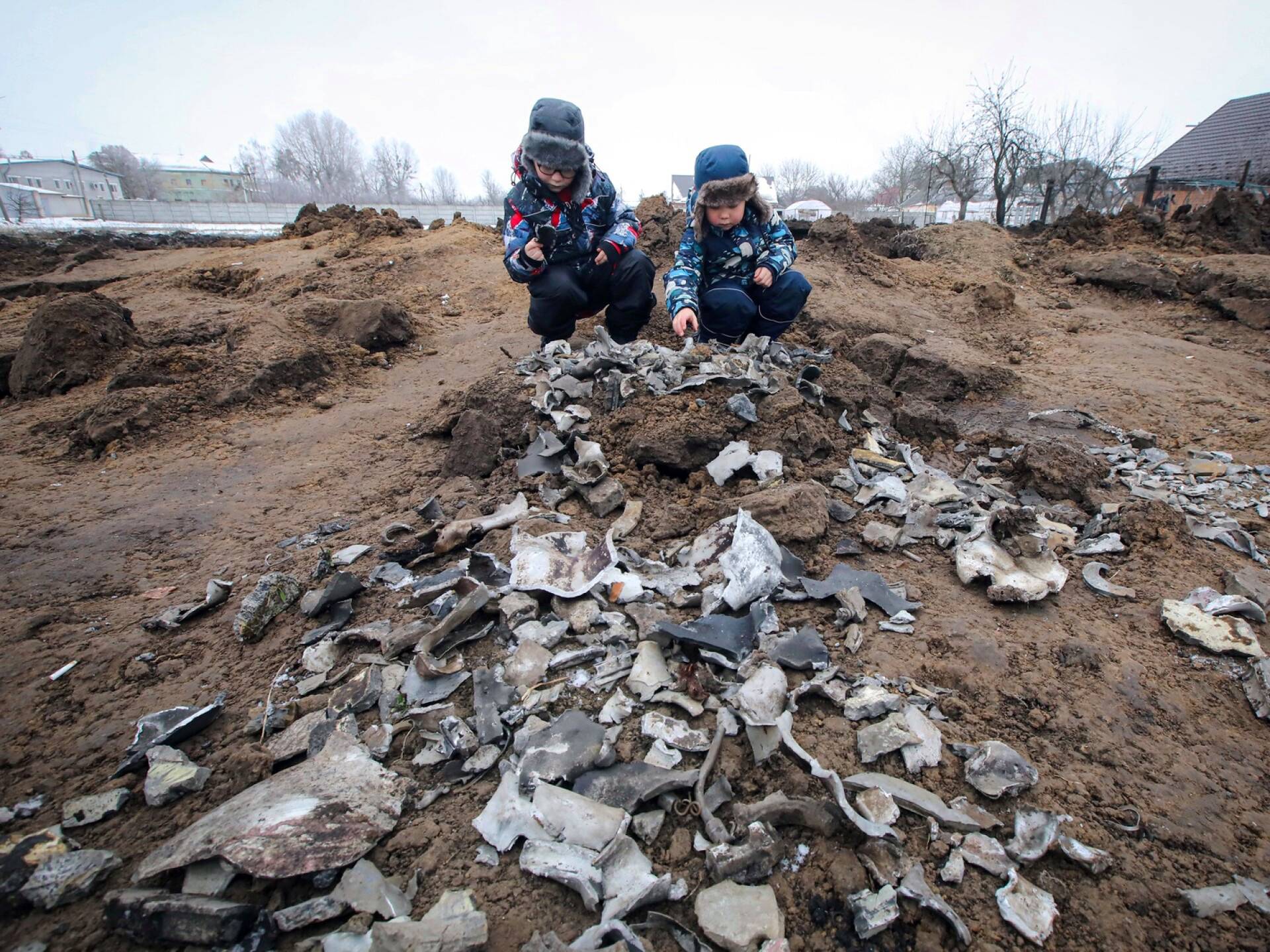Lapset poimivat raketin palasia maasta Kopylivissa Kiovan lähistöllä tammikuussa.