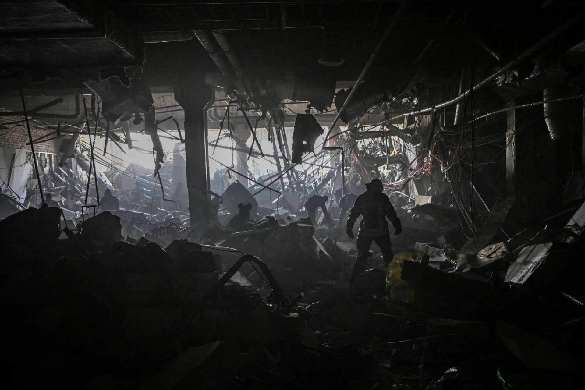 Ukrainalaissotilas Venäjän iskun vaurioittamassa Retroville-ostoskeskuksessa Kiovassa maanantaina.