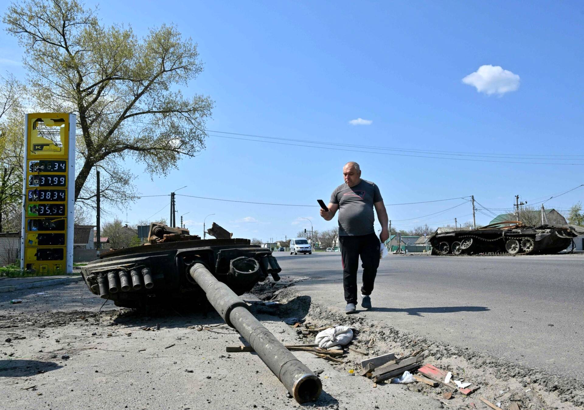 Mies kuvasi venäläistankin jäänteitä tuhotun huoltoaseman vieressä Skybynin kylässä.