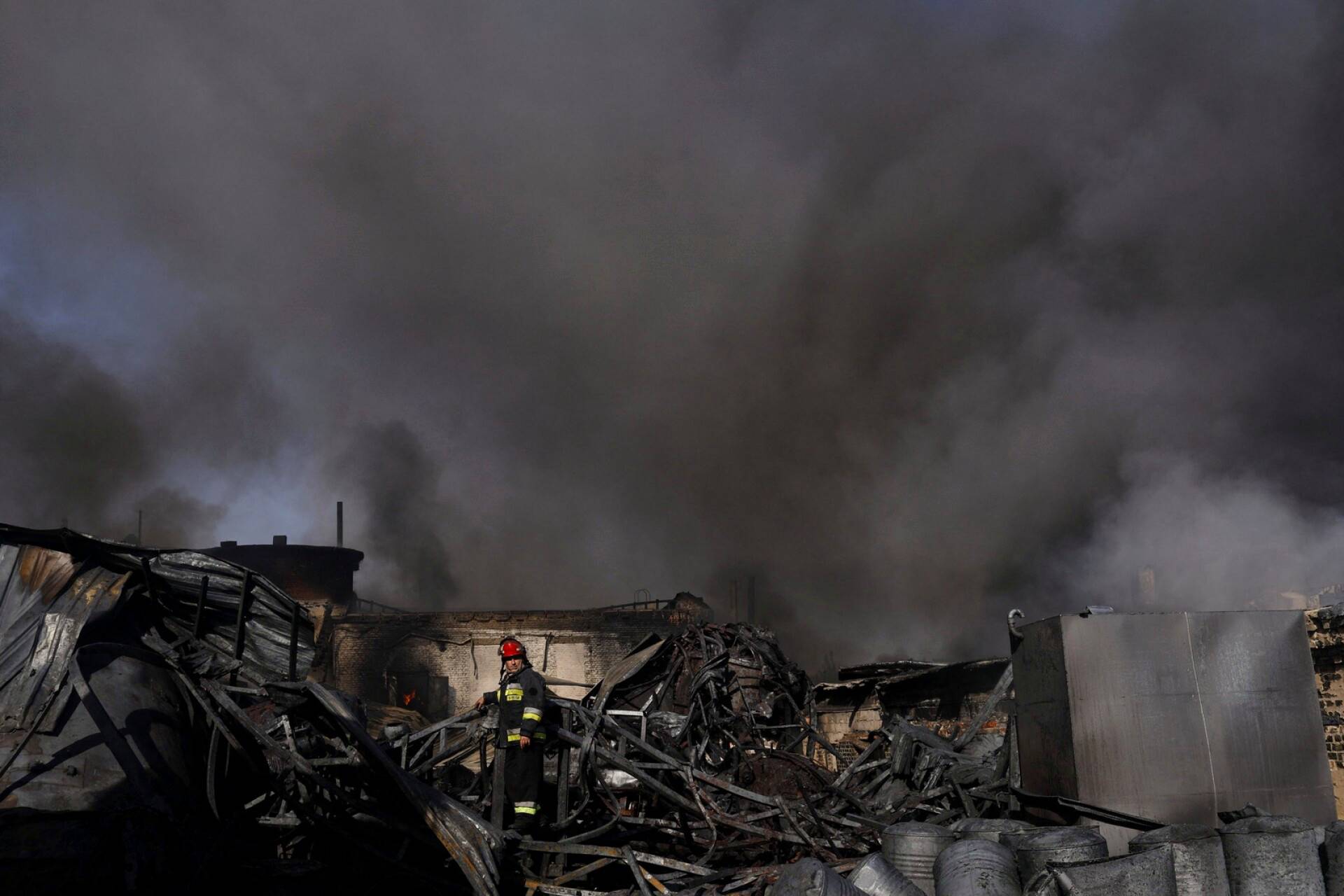 Palomiehet sammuttavat venäläisten pommituksessa syttynyttä tehdasta Harkovassa. 