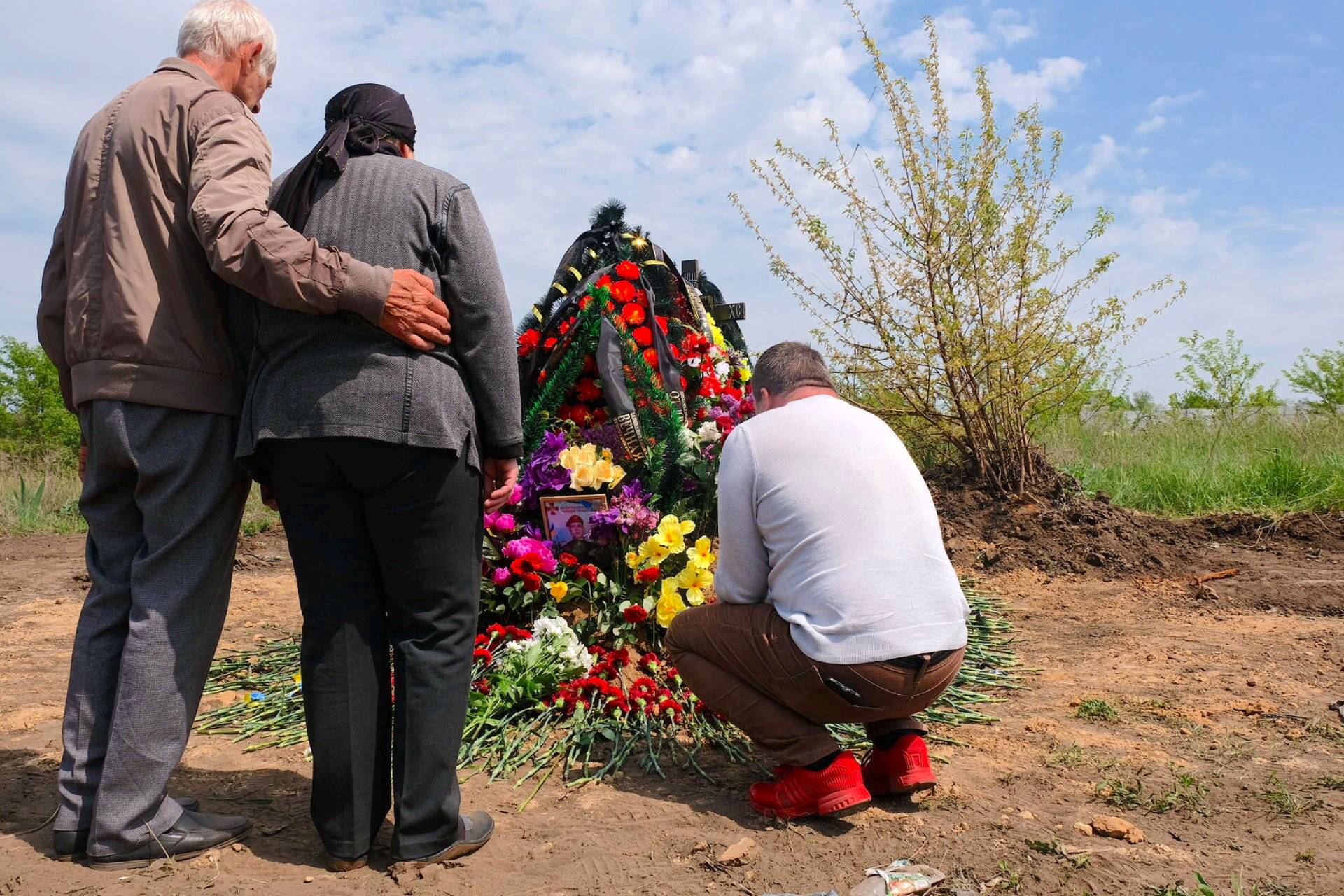 Vanhemmat ja veli surevat sodassa kuolleen sotilaan Sergey Titovin haudalla. 
