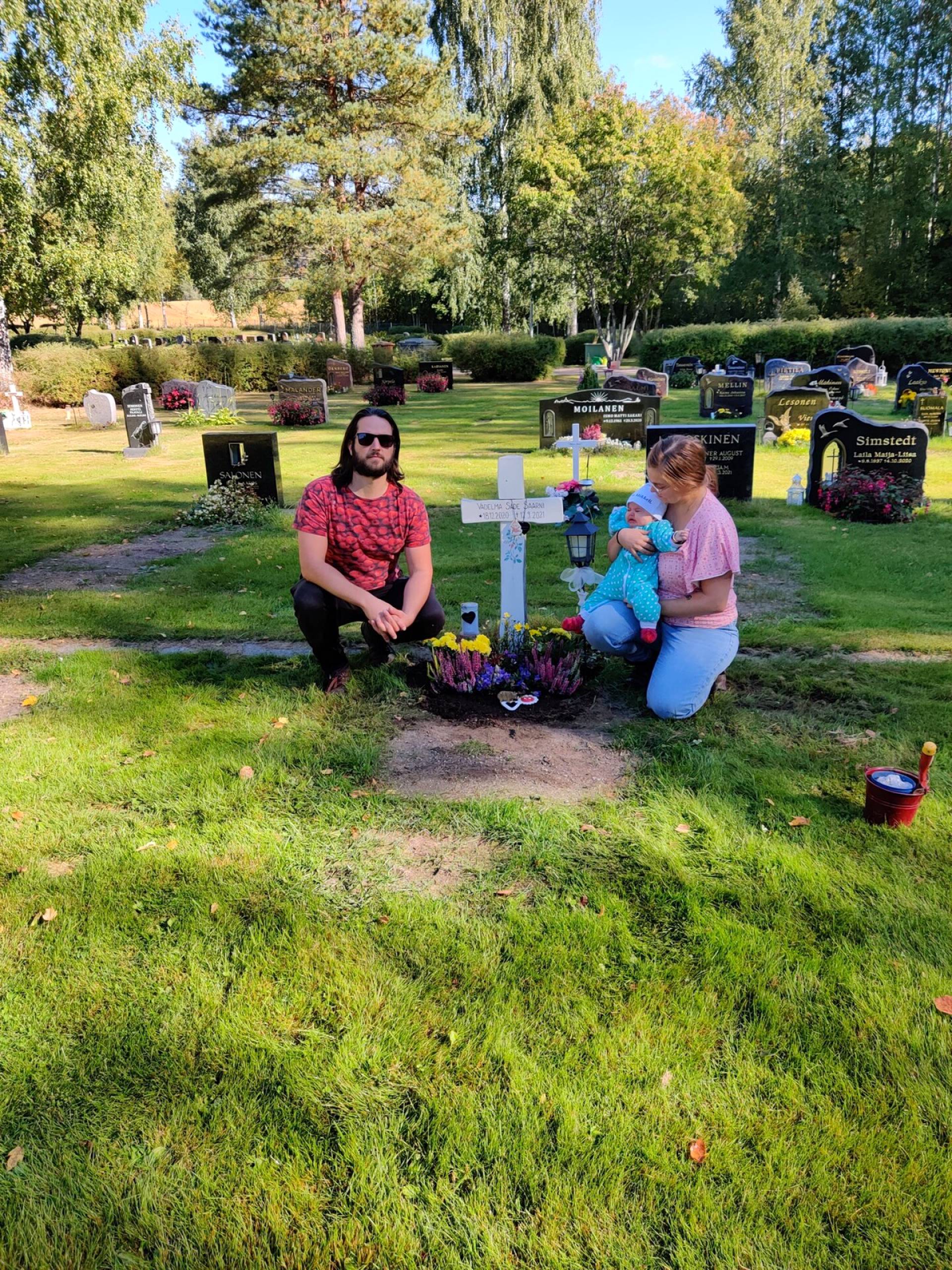Matti, Meri ja Orvokki Vadelman haudalla.