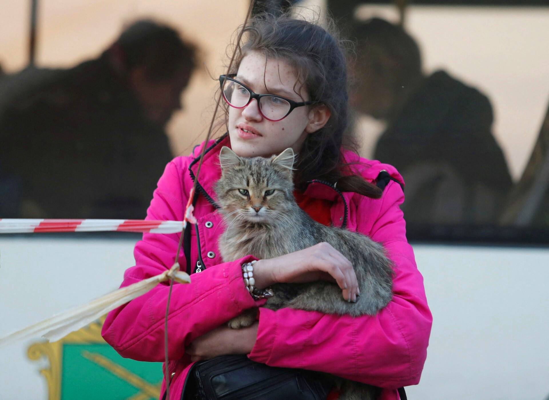 Nuori nainen odotti kissa sylissään evakuointibussiin nousemista Bezimennessä, Donetskin alueella.