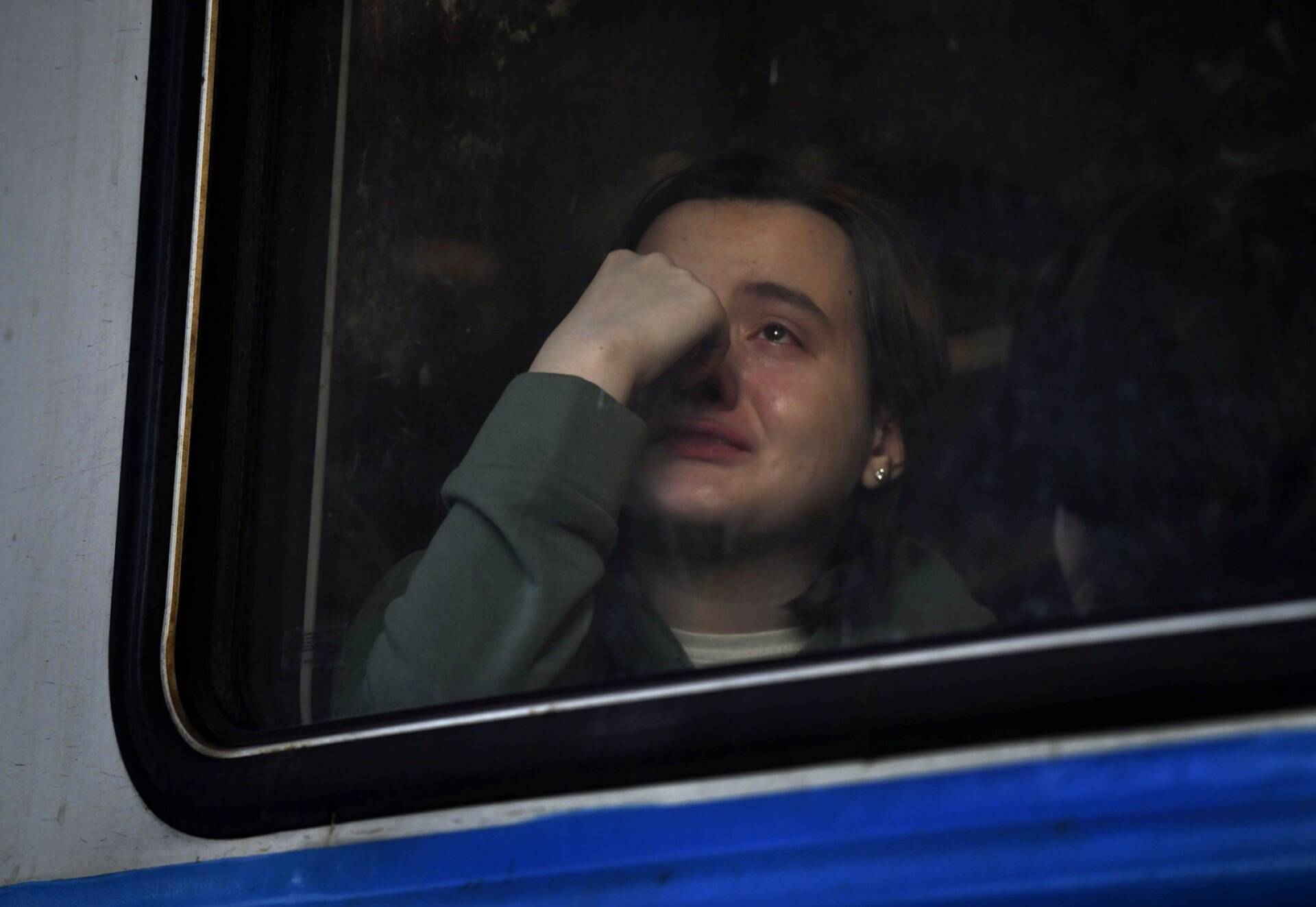 Lvivistä Puolaan pakeneva nainen kyynelehti junan ikkunassa.
