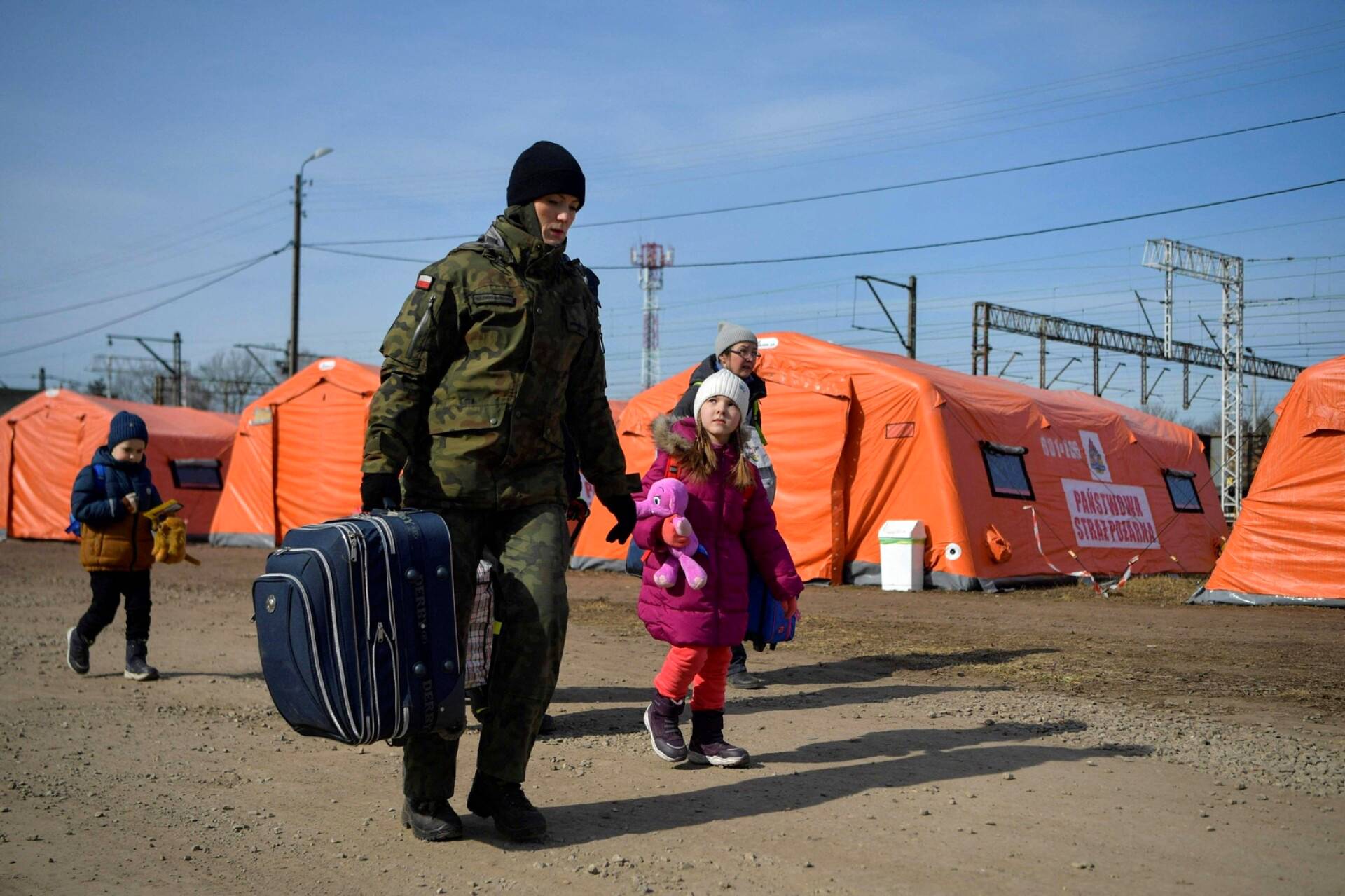 Puolalaissotilas auttoi perhettä ylittämään Ukrainan rajan Medykassa Puolassa.