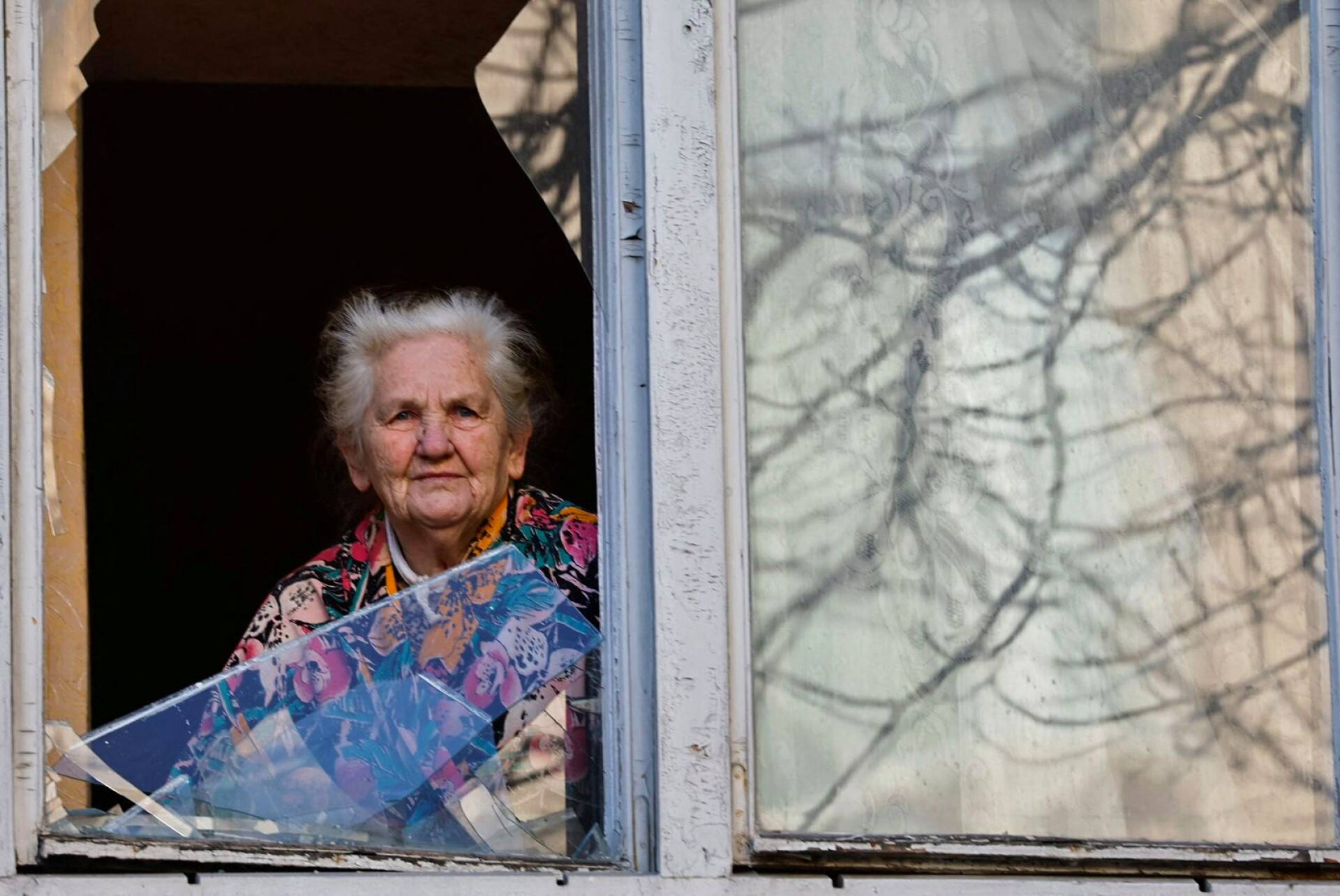 Nainen katsoi ulos ikkunasta Kiovassa.