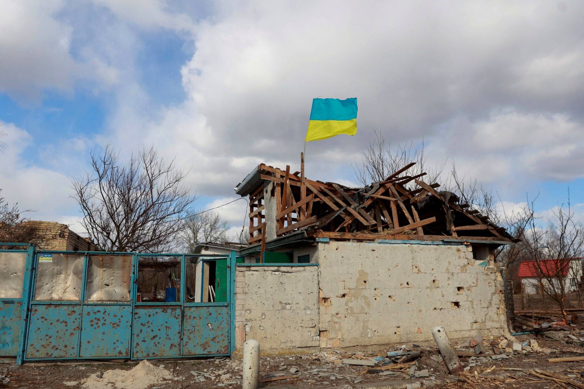 Ukrainan lippu heiluu tuhotun talon yllä Lukianivkassa Kiovan alueella. 