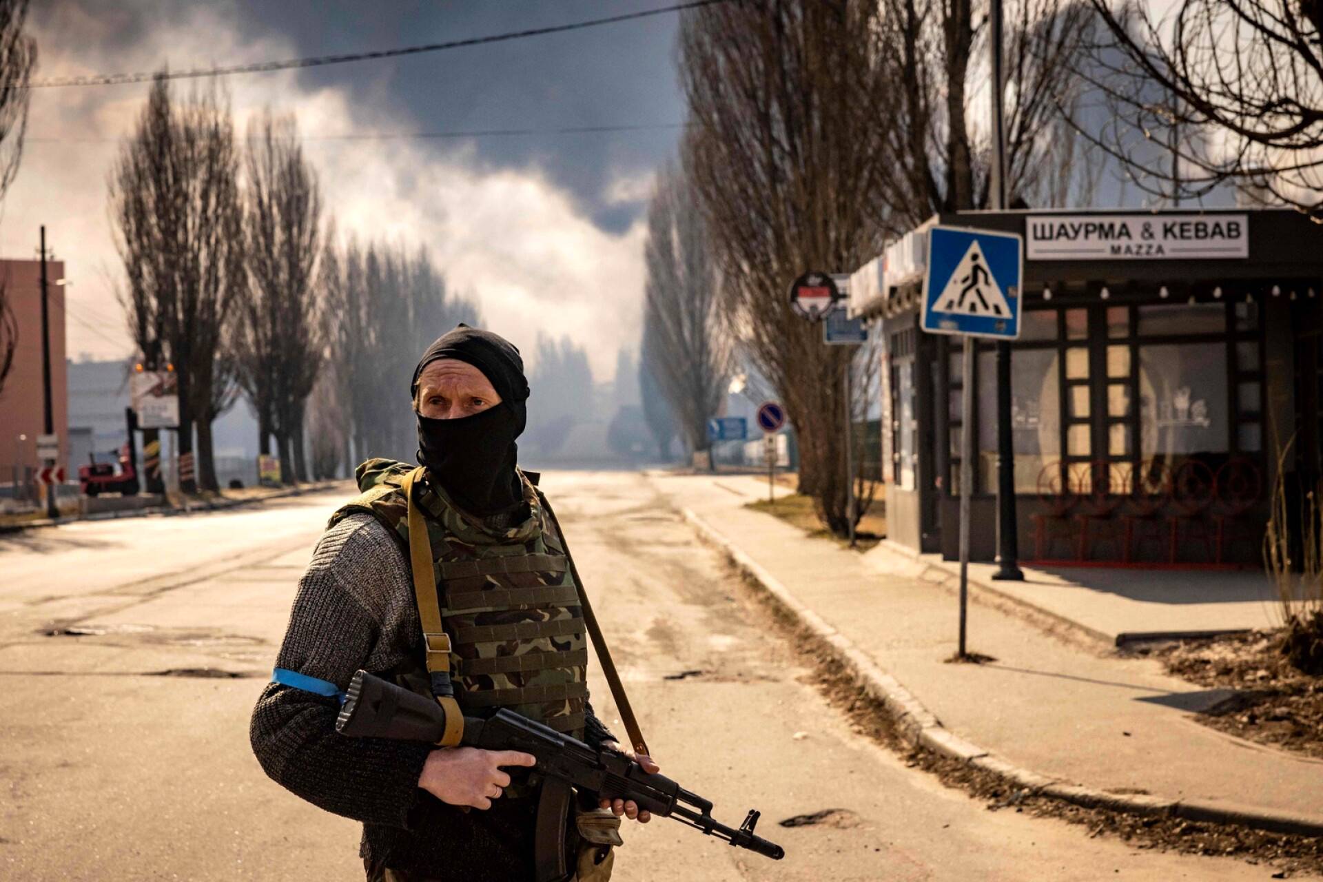 Ukrainalaissotilas oli vartiossa Kiovassa, lähellä palavaa varastorakennusta.