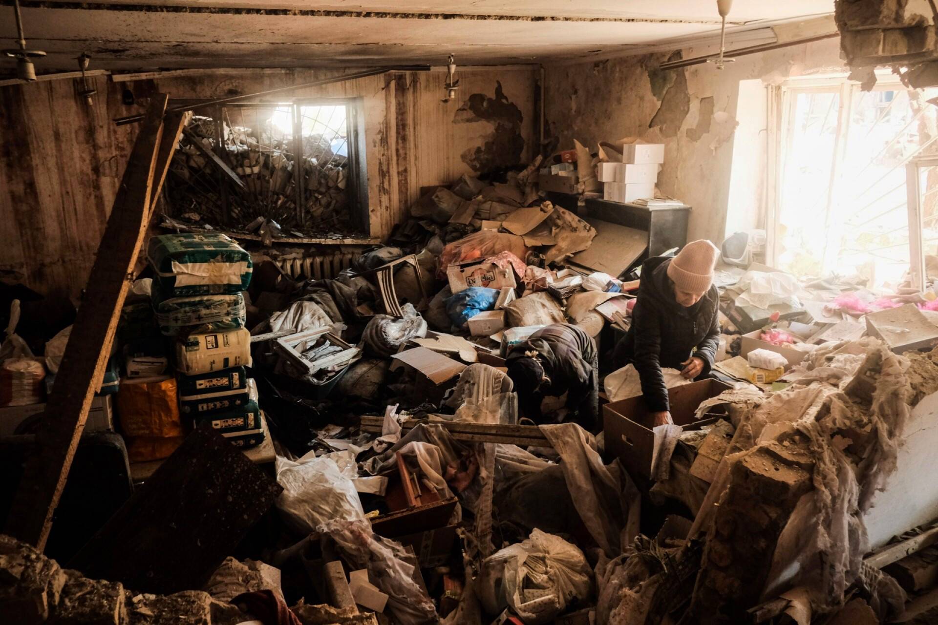 Asukkaat setvimässä raunioihin jääneitä tavaroita Kiovassa lauantaina.
