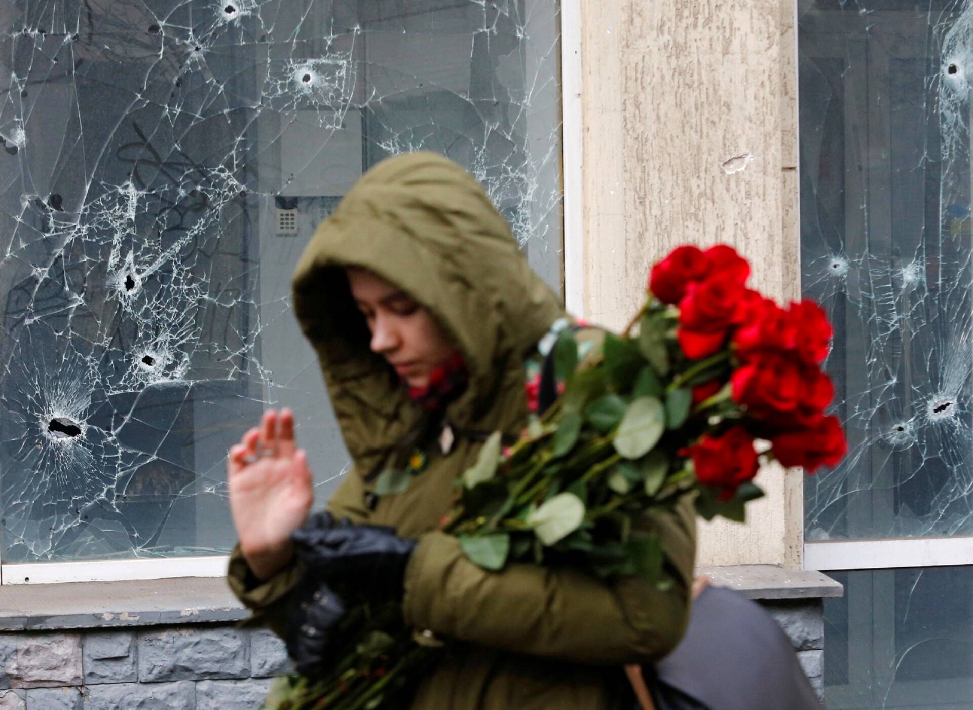 Nainen vei kukkia sodan uhrien muistomerkille Donetskissa.