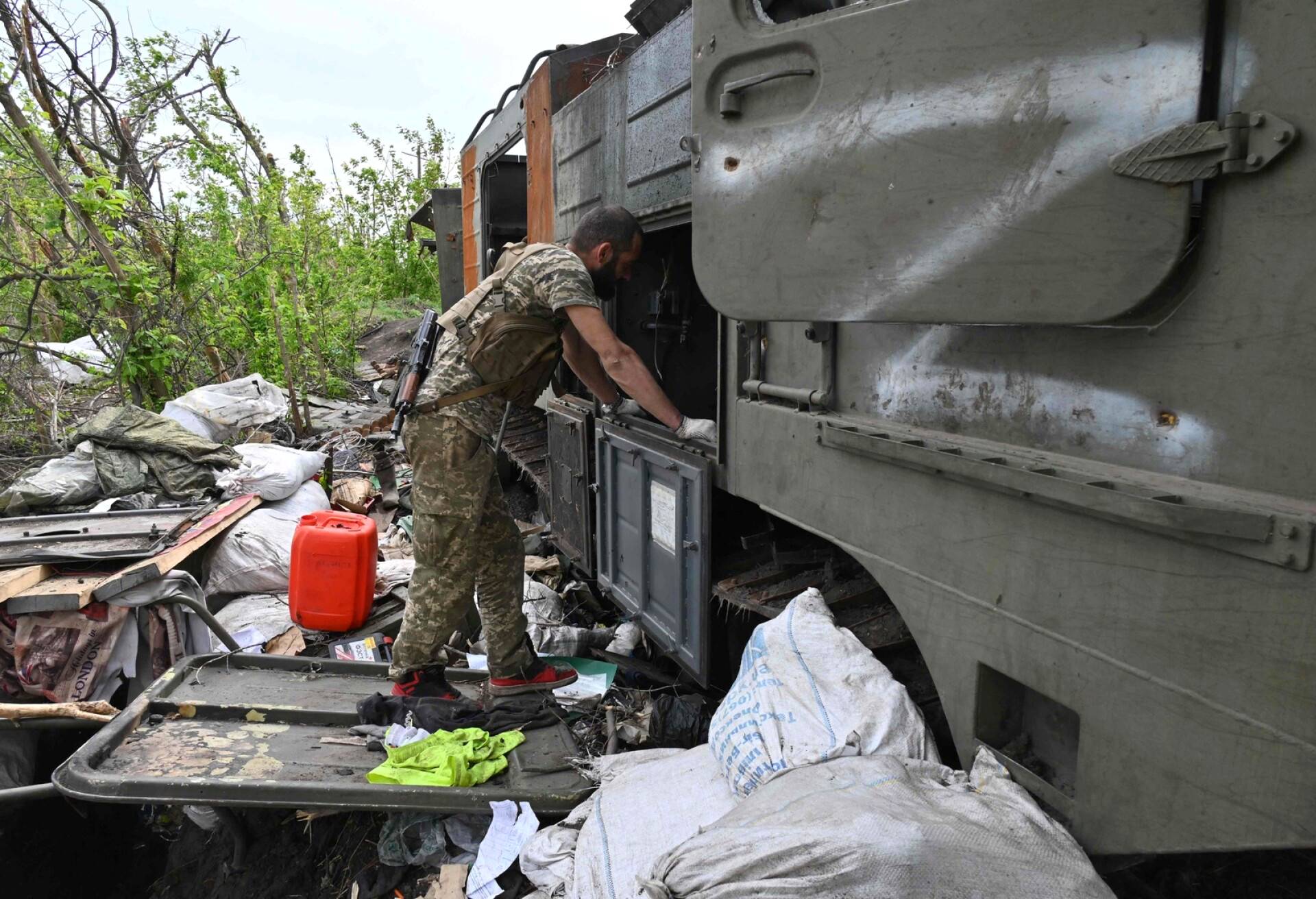 Ukrainalainen sotilas tutkii tuhoutunutta venäläistä sotilasajoneuvoa Mala Roganin kylässä. 