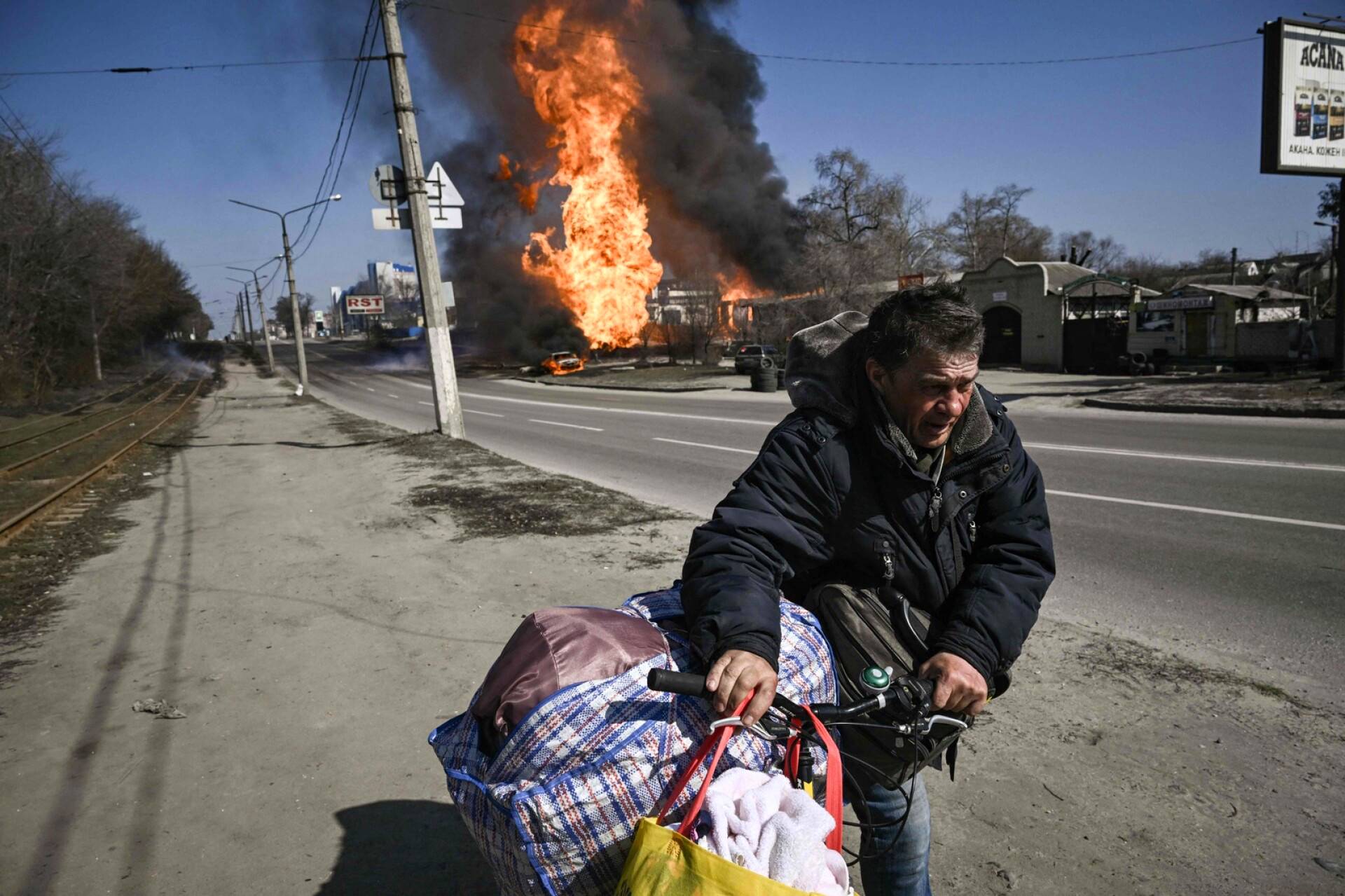 Mies liikkeellä tavaroidensa kanssa Venäjän iskujen moukaroimassa Harkovassa.