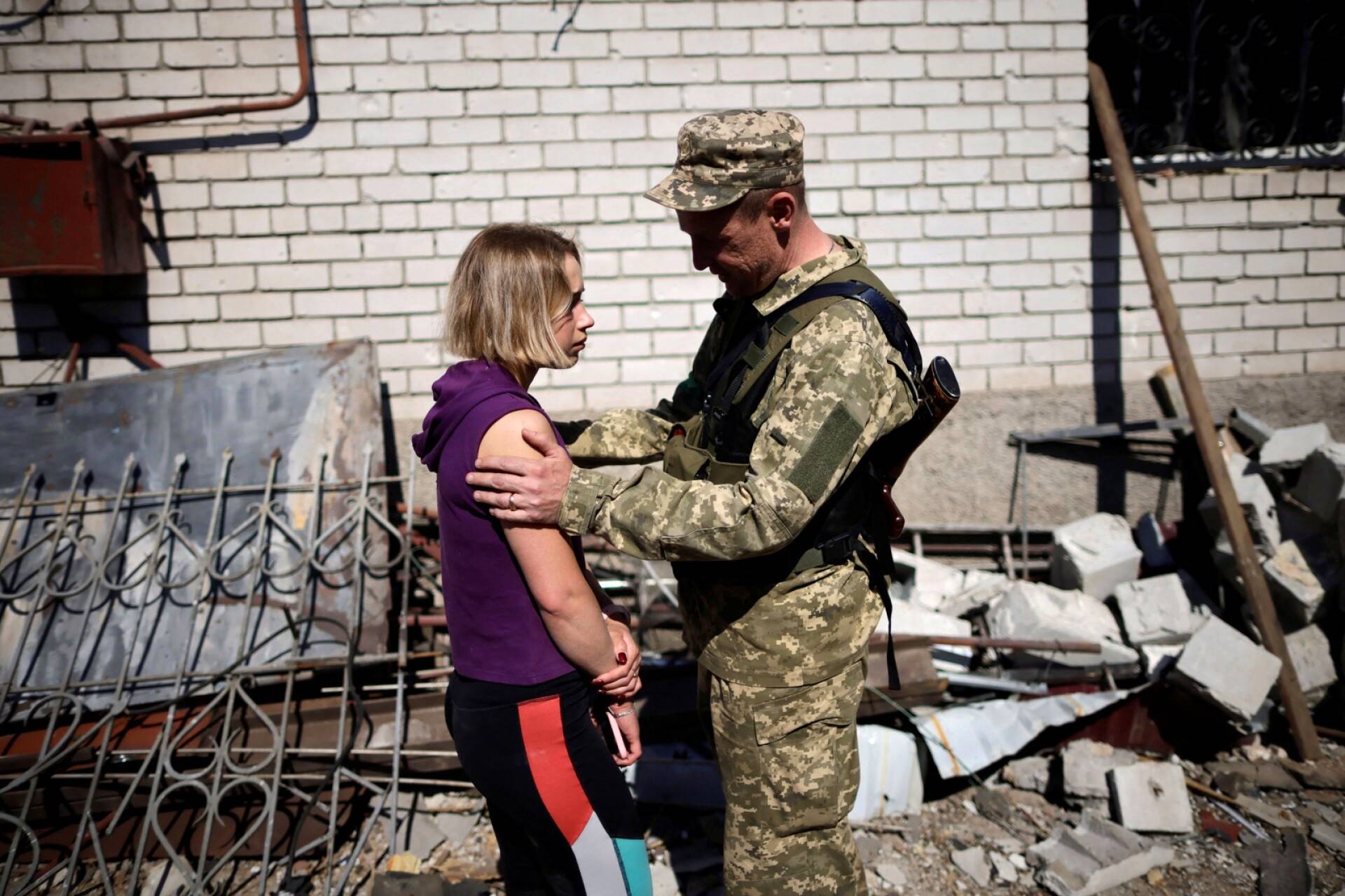 Sotilas lohdutti naista, jonka asunto tuhoutui Venäjän hyökkäyksessä.