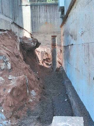 Kuvassa näkyy betonilohkare, joka paljastui maata poistettaessa tukimuurin kyljestä.