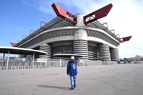 Mies seisoo San Siron stadionin ulkopuolella. Inter Milanin oli määrä kohdata stadionilla Sampdoria Serie A:n ottelussa sunnuntaina, mutta ottelu jouduttiin perumaan koronaviruksen takia.