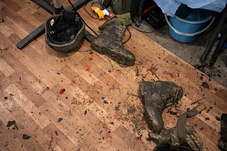 Haavoittuneen sotilaan kengät lääkintäpisteen lattialla.