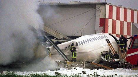 Palomiehet yrittivät sammuttaa palavaa SAS:n konetta, joka törmäsi matkatavaroidenkäsittelyhalliin Linaten kentällä 8. lokakuuta 2001.