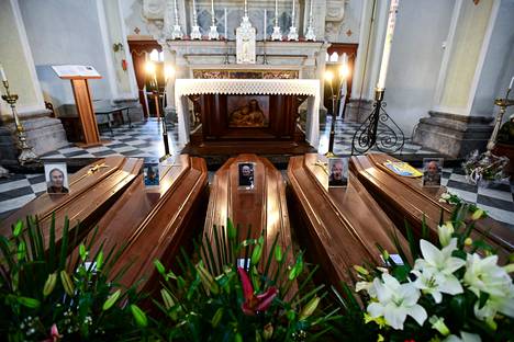 Hautaamista odottavia arkkuja kirkossa Serinassa Bergamon lähellä lauantaina.