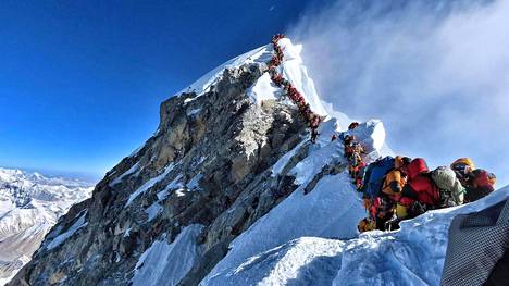 Kiipeilijöiden päättymätön letka Mount Everestin huipulla.