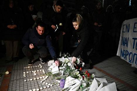 Ihmiset sytyttivät kynttilöitä uhrien muistoksi Larissan rautatieaseman ulkopuolella.