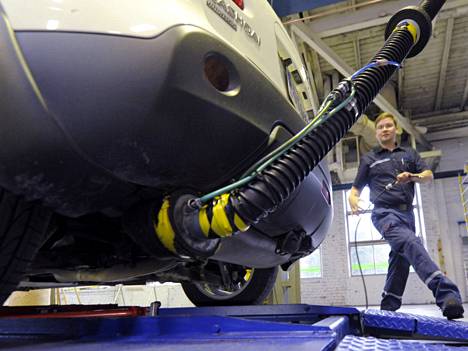 Katsastusmies Harri Kaurila mittaa bensiinikäyttöisen auton pakokaasupäästöjä.