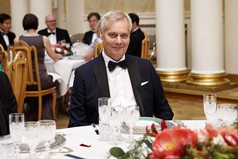 Pääministeri Antti Rinne hymyili illallispöydässä.