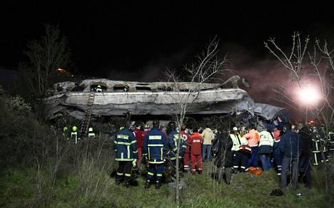 Pelastushenkilökuntaa etsimässä matkustajia romuttuneesta junanvaunusta. 