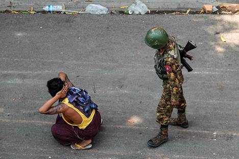 Sotilas ja pidätetty mielenosoittaja Mandalayssa 3. maaliskuuta.