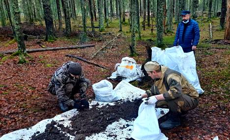 Venäläisen Severo-Zapad -etsintäryhmän jäsenet erottelevat Karjalankannakselta löytämiään suomalaissotilaiden jäänteitä.