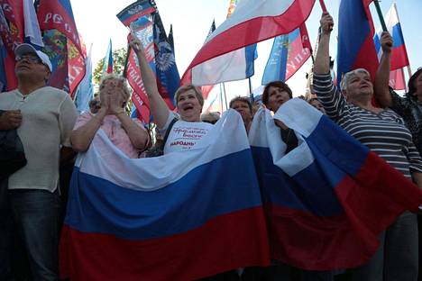 Venäjän lippua heilutelleet luhanskilaiset juhlivat ”alueliitoksia”, jotka on julistettu lännessä laittomiksi.