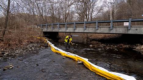 Yhdysvaltain ympäristönsuojeluviraston työntekijä tutkii Ohion East Palestinessa sijaitsevaa jokea haitallisten kemikaalien varalta.