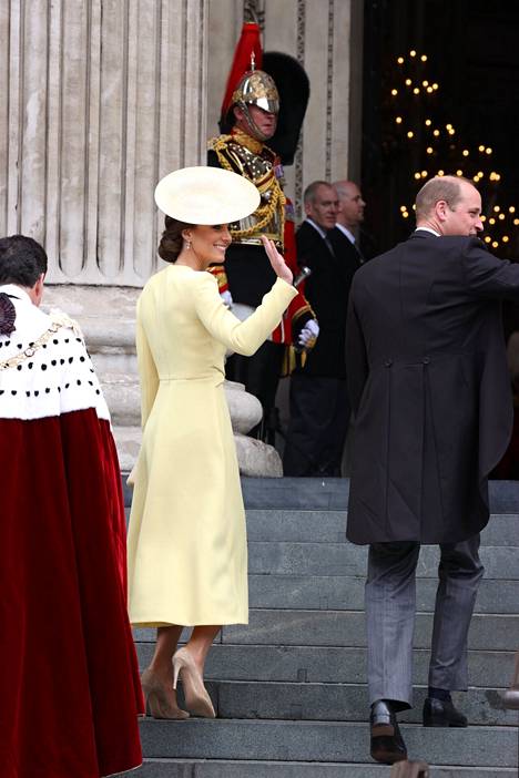 Herttuatar Catherine oli pukeutunut vaaleankeltaiseen asuun. Prinssi Williamilla nähtiin tuttu pitkä ja tumma puvuntakki sekä harmaat puvunhousut.