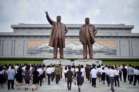 Pohjoiskorealaiset viettivät maanantaista juhlapäivää Kim Il-sungin ja Kim Jong-unin patsaiden edessä.