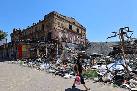 Nainen käveli tuhoutuneiden rakennusten ohi Mariupolissa heinäkuussa.
