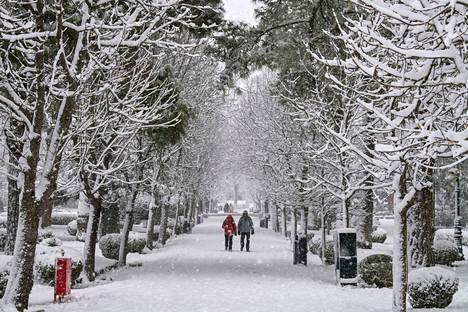 Paikalliset asukkaat kävelyllä lumisateen aikana Ateenan pohjoisosassa.