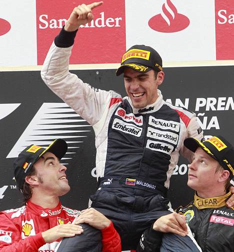 Fernando Alonso ja Kimi Räikkönen nostivat Pastor Maldonadon kultatuoliin Espanjan F1-kisan palkintojenjaossa 2012.