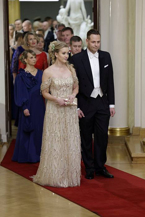 Sofia Virta oli pukeutunut paljetein, helmin ja metalliketjuin koristeltuun vaaleankultaiseen pukuun, jonka suunnittelija on Saara Kuusjärvi.