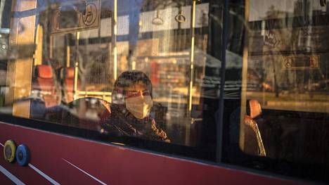 Kasvonsa maskilla suojannut iranilaisnainen matkusti tiistaina bussilla Teheranissa.