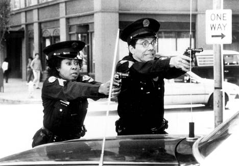 Laverne Hooks (Marion Ramsey) ja kokelas Douglas Fackler (Bruce Mahler) ammuskelevat Poliisiopisto-sarjan toisessa osassa.