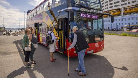 Matkustajia nousemassa bussin kyytiin kohteenaan Senaatintori. 