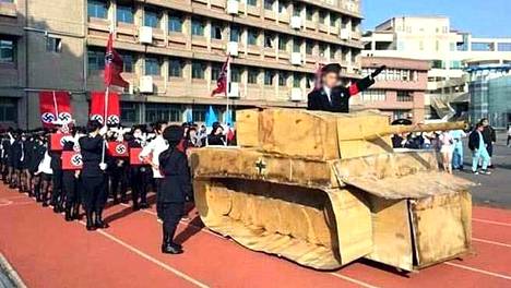 Kuva taiwanilaisen yläkoulun perjantaina järjestämästä paraatista. Pahvisessa tankissa natsitervehdystä tekevän henkilön kerrotaan olevan koulun historianopettaja.