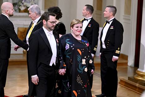 Keskustan puheenjohtaja Annika Saarikko oli pukeutunut tummapohjaiseen printtikuosiin. Käsipuolessa aviomies Erkki Papunen.
