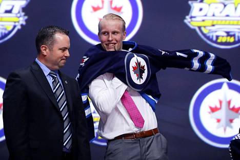 Patrik Laine puki Winnipeg Jetsin paidan päälleen NHL:n varaustilaisuudessa 24. kesäkuuta Buffalossa.